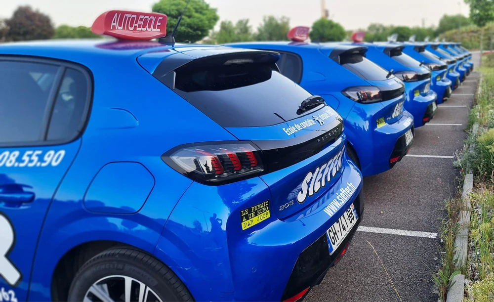 Flotte de véhicules d'auto-école alignés dans un parking